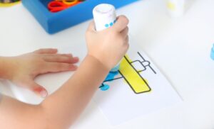 child coloring airplane page with dot markers