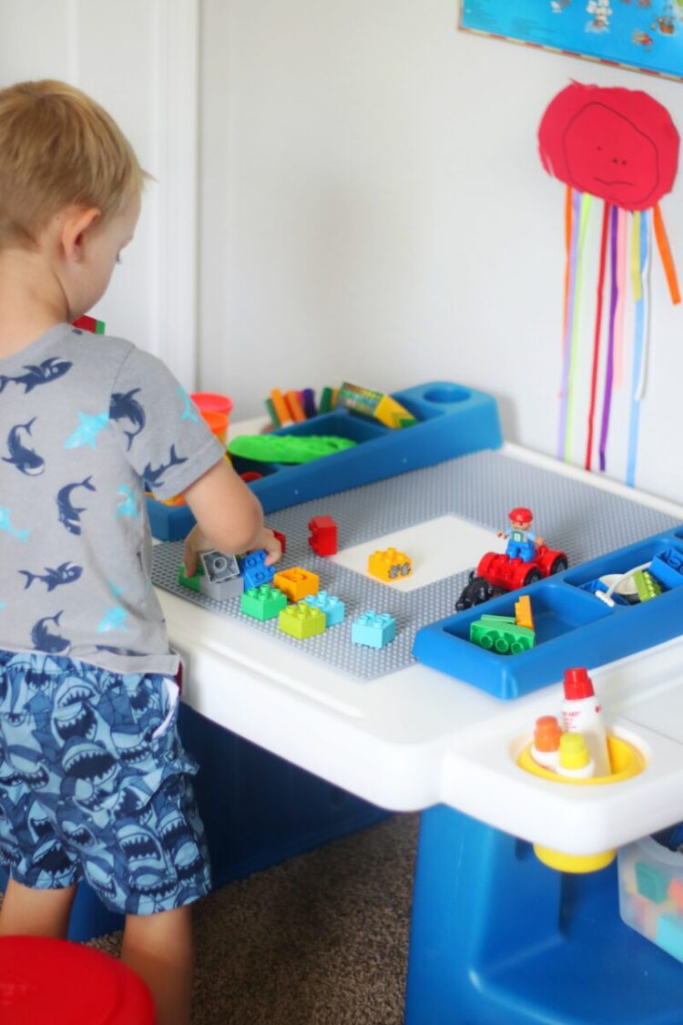 child stating next to preschool table