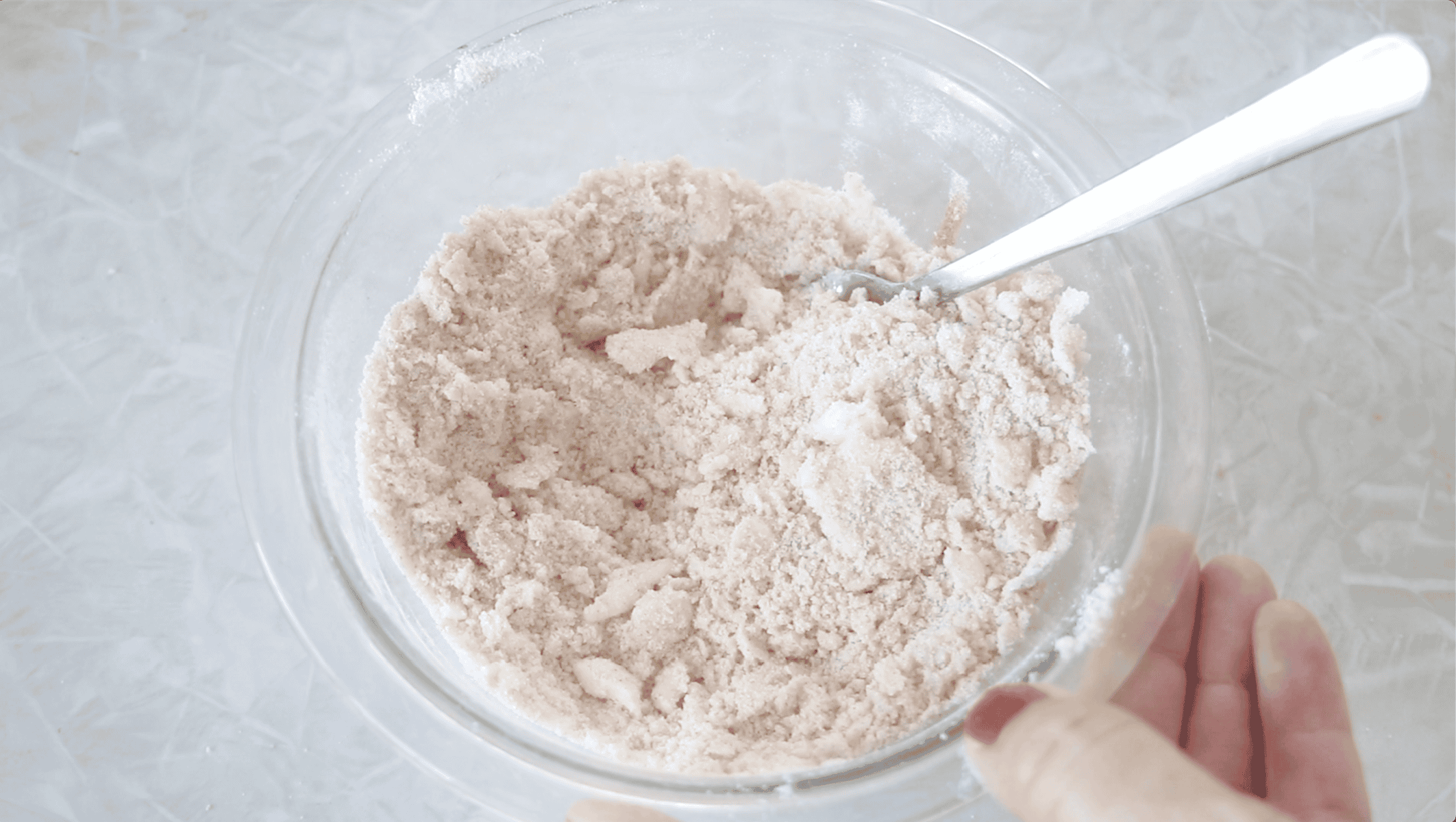 Glass bowl with crumbled butter, flour, sugar and cinnamon.