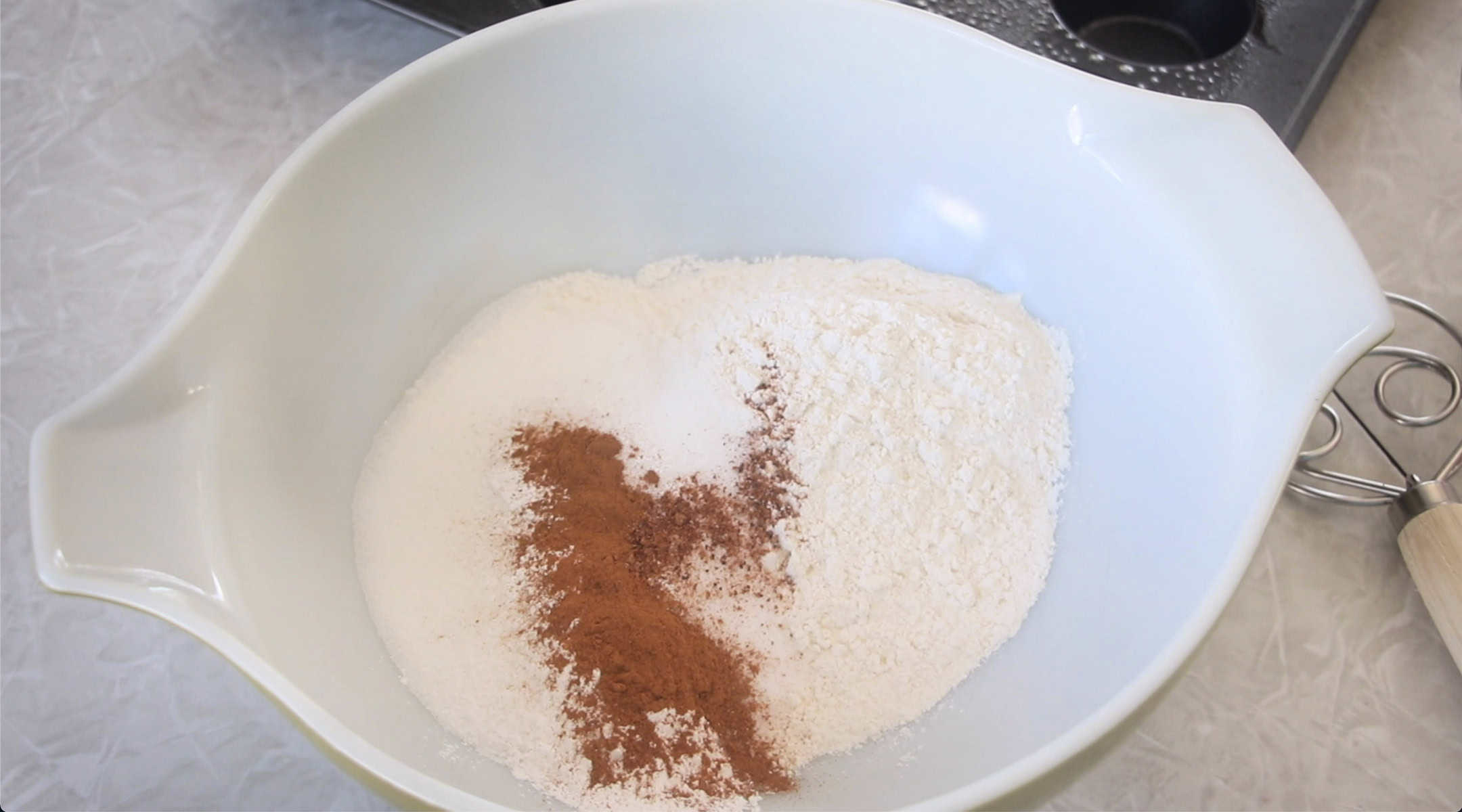 Mixing bowl with flour, cinnamon, salt, baking powder and nutmeg.