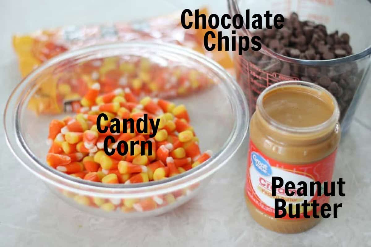 Bowl of candy corn, jar of peanut butter, and bowl of chocolate chips.