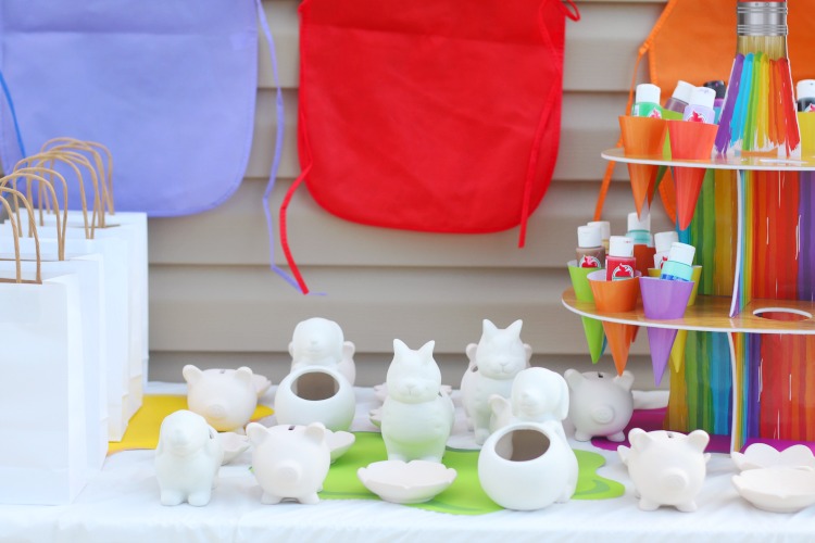 unpainted pottery on table next to white gift bags