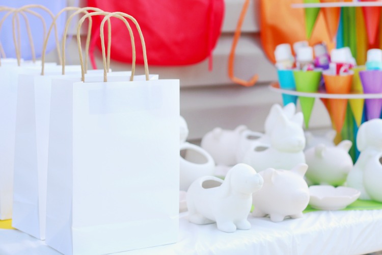 white gift bags to put finished pottery in next to unpainted pottery