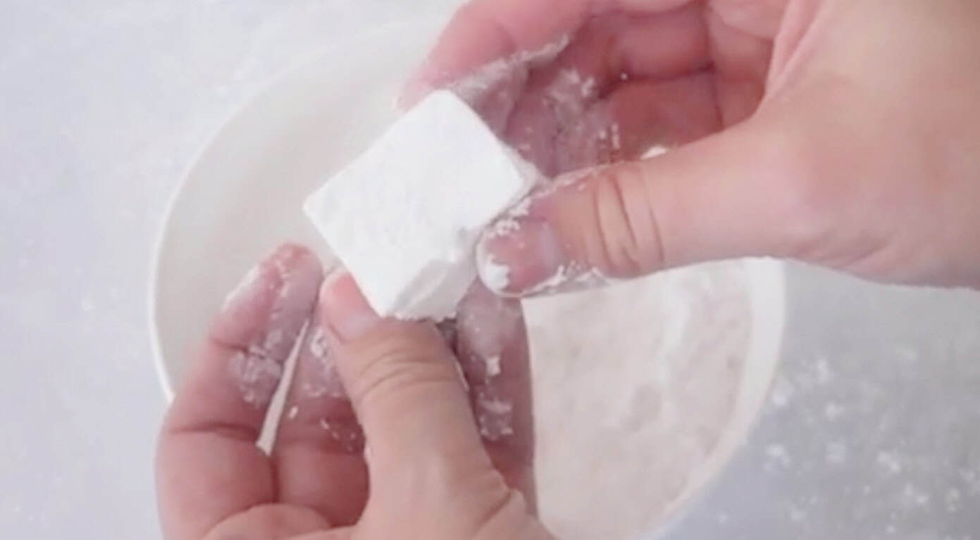 Hand holding marshmallow.