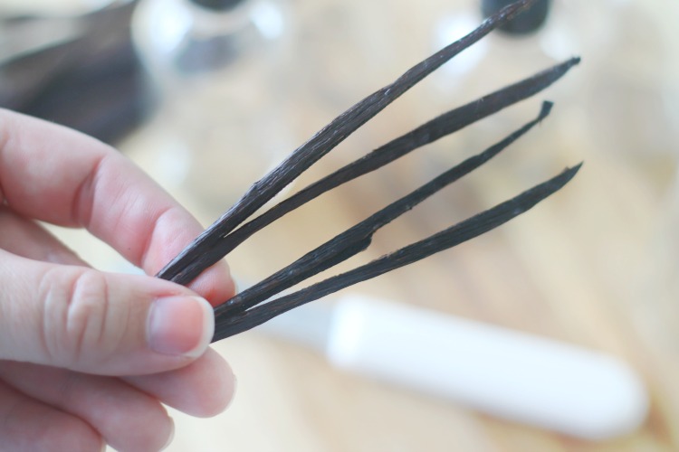 hand holding two sliced vanilla pods