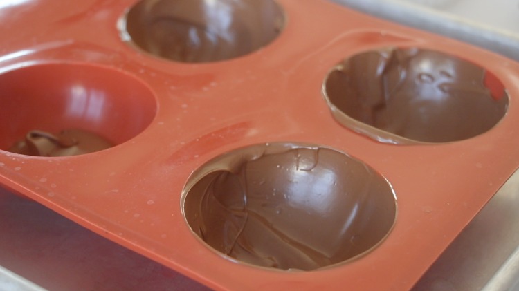 silicone chocolate mold with chocolate spooned inside