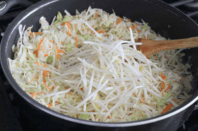 Large fry pan with coleslaw mix and bean sprouts.