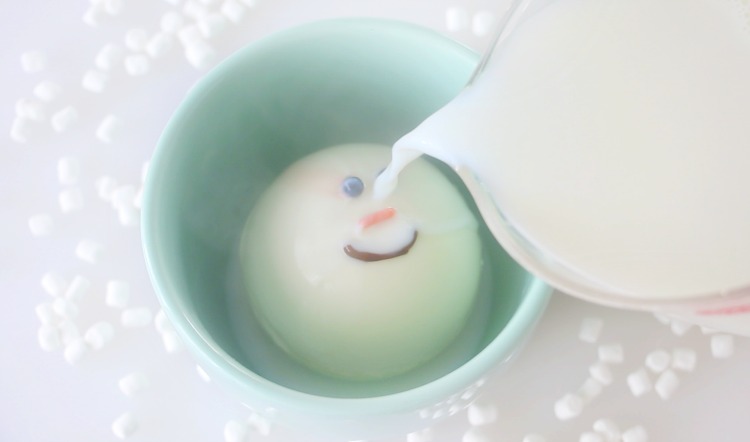 snowman hot chocolate bomb with hot milk being poured on top