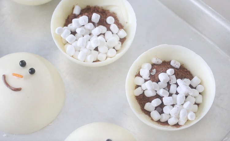 chocolate cups filled with hot chocolate mix and marshmallows