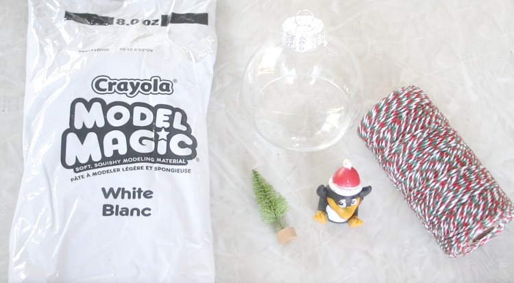 white model magic next to penguin finger puppet and clear ornament