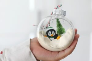 child holding penguin ornament