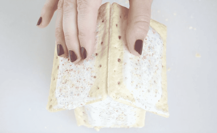 Hands holding two pop tarts in place for roof.