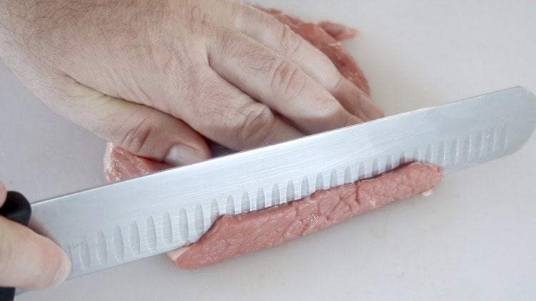 sharp knife slicing jerky meat