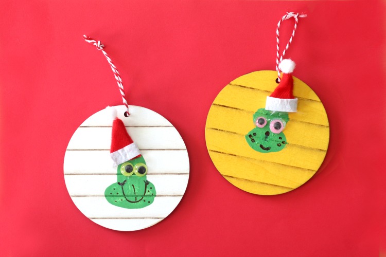two thumbprint grinch ornaments on red background