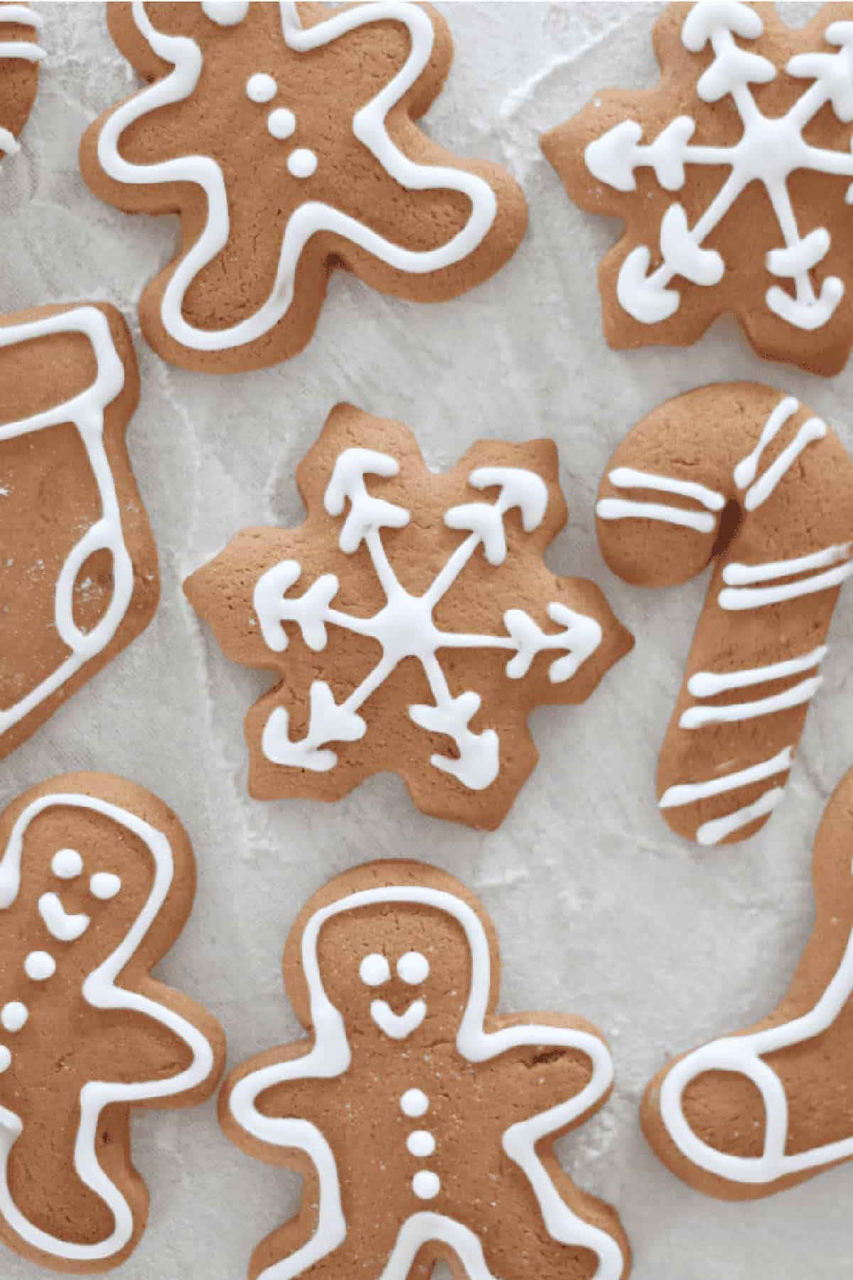 Cutout gingerbread cookeis iced with white outlines.