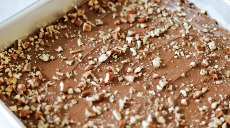 toffee bars spread with melted chocolate and sprinkled with chopped pecans
