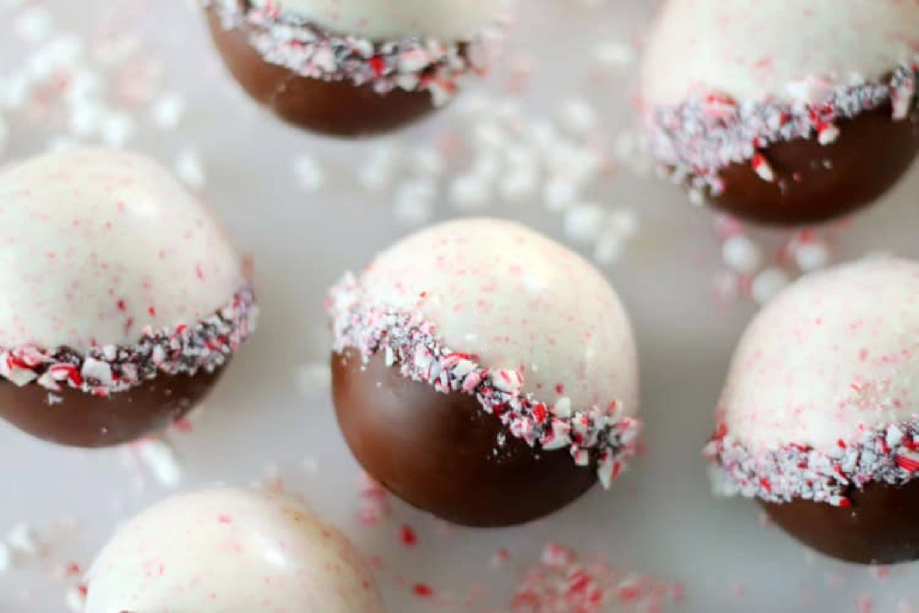 Peppermint hot cocoa bombs on cutting board.