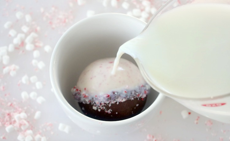 pouring hot milk over peppermint bark hot chocolate bomb