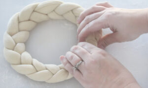 hands bringing ends of pretzel braid together