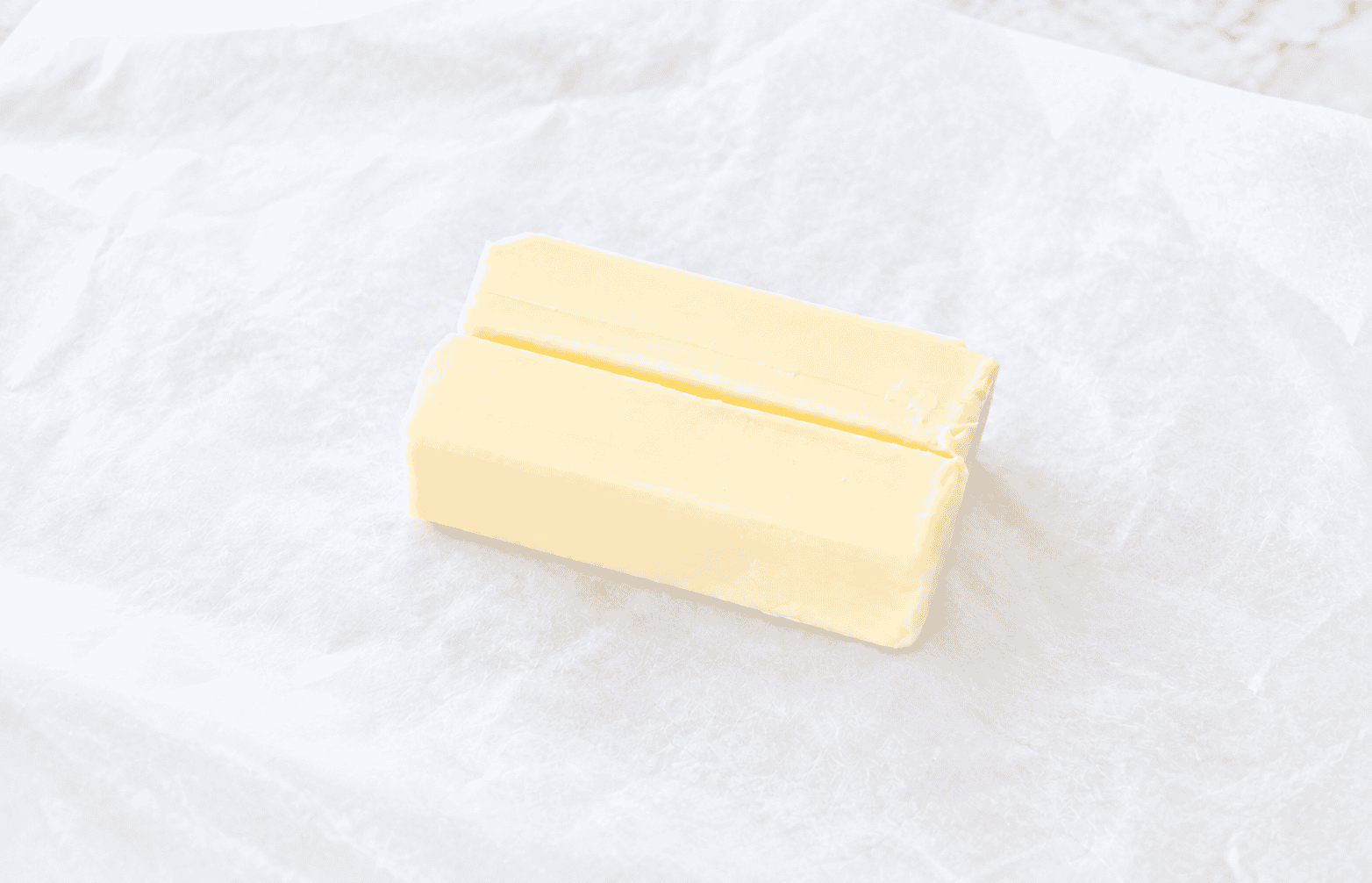 Two sticks of butter on parchment paper.