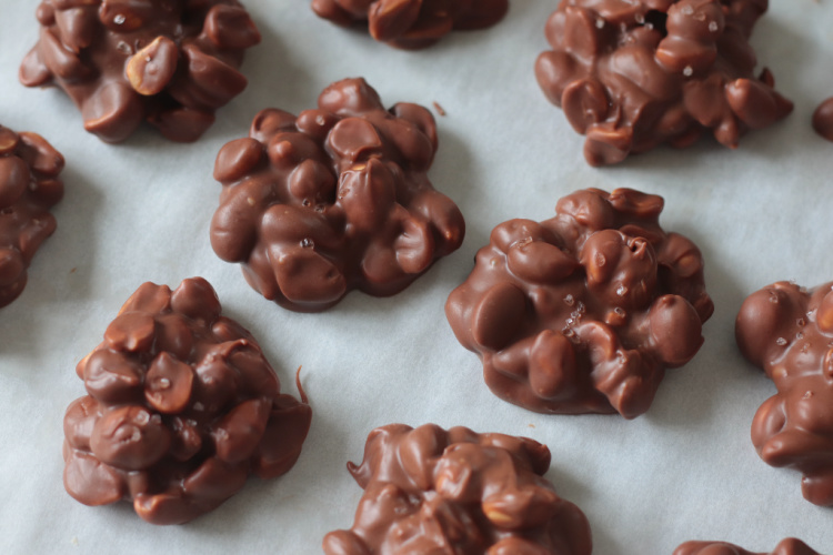 pieces of chocolate butterscotch crockpot candy on parchment paper