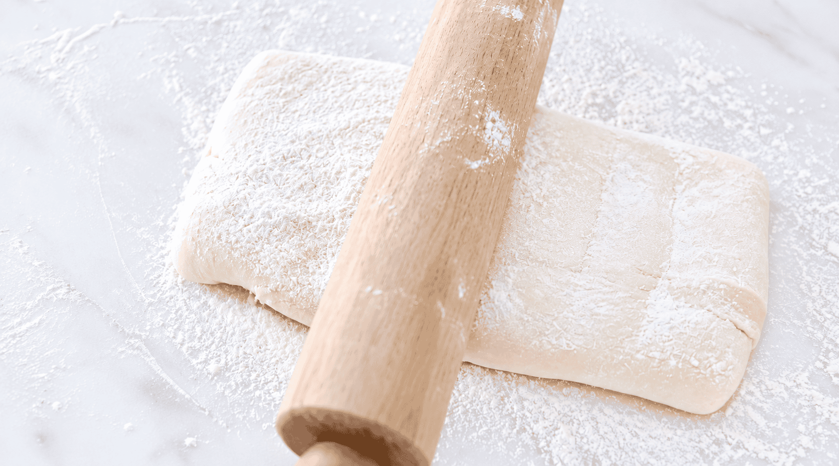 Croissant dough rolled out with rolling pin.