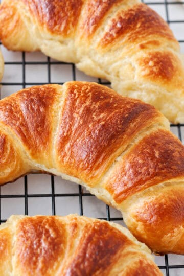 Croissants on a wire cooling rack.