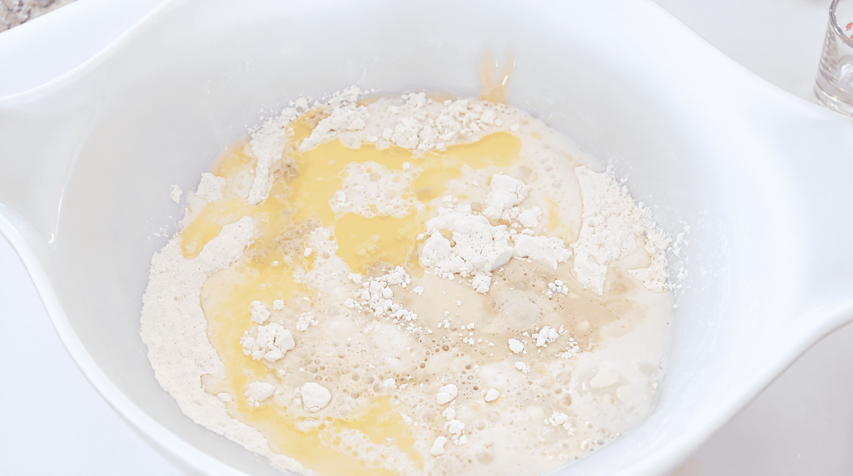 Bowl of yeast mixture, melted butter and flour.