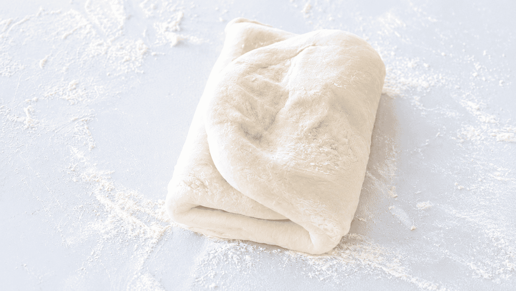 Croissant dough rolled into thirds.