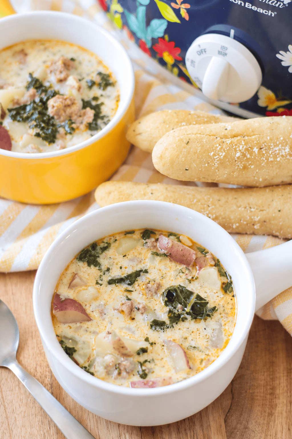 Two bowls of soup and pile of breadsticks.