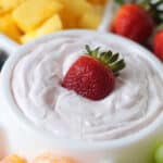 White bowl of yougurt fruit dip with strawberry.