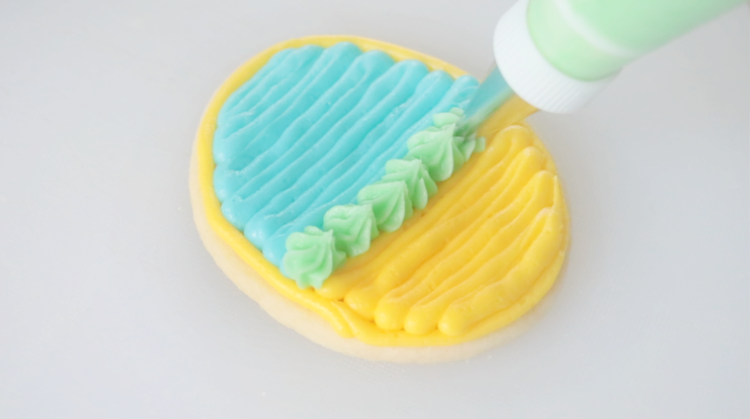 egg shaped cookie with yellow, blue and green frosting