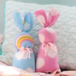 Two fleece bunnies placed against a pillow.