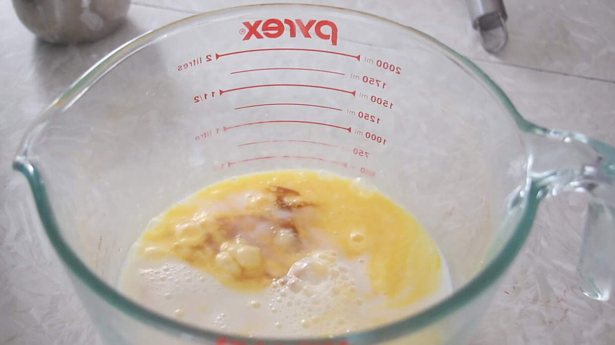 Mixing bowl with eggs, milk, salt and vanilla.