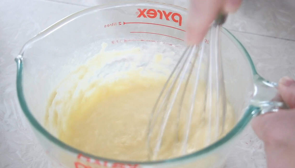 German pancake batter in mixing bowl with whisk.