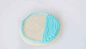 round sugar cookie outlined in blue frosting