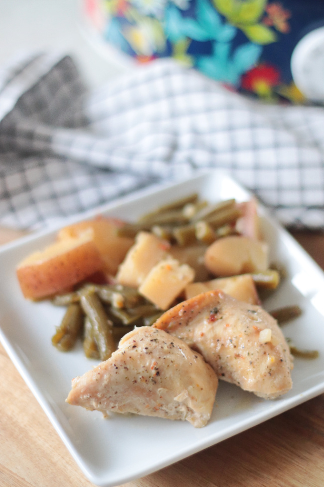 white plate with chicken, potatoes and green beans
