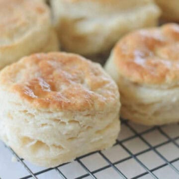 Wire cooling rack with fresh baked biscuits on it.