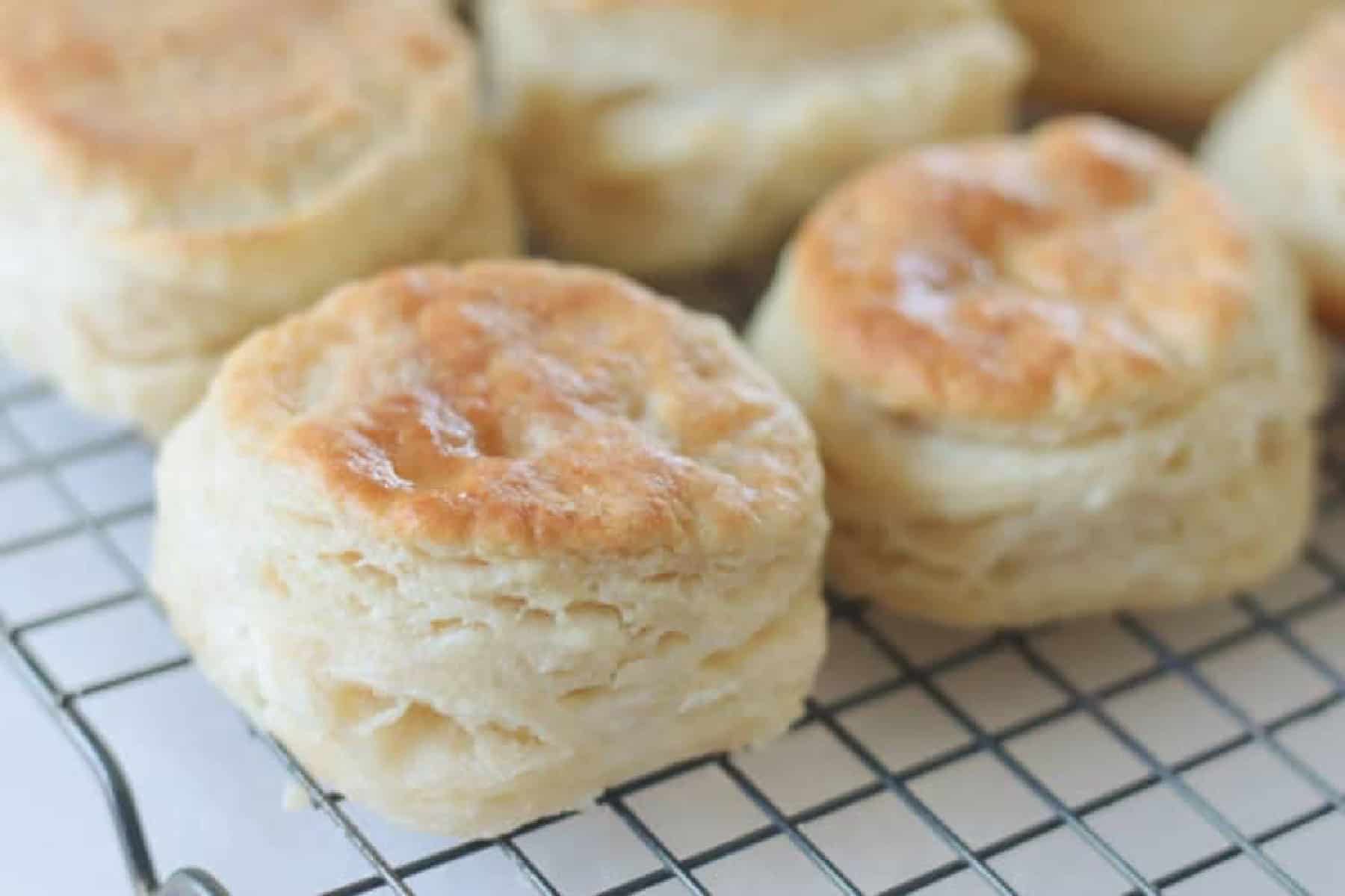 Wire cooling rack with fresh baked biscuits on it.