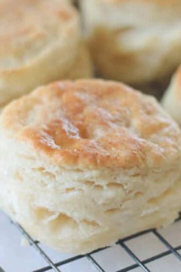 Wire cooling rack with fresh baked biscuits on it.