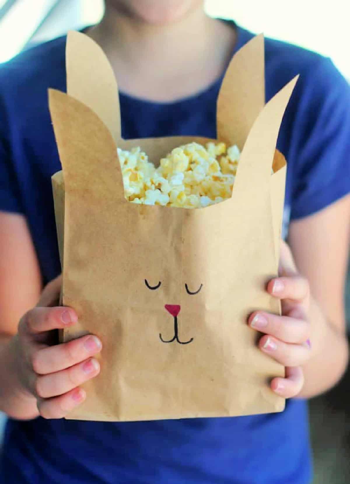 Girl holding brown bunny treat bag.