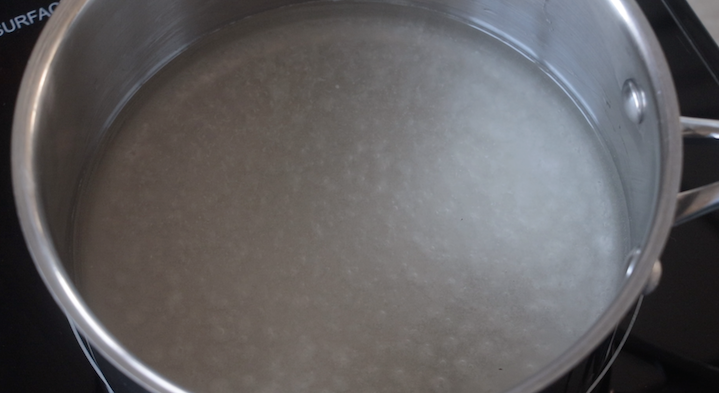 water and sugar simmering in pan