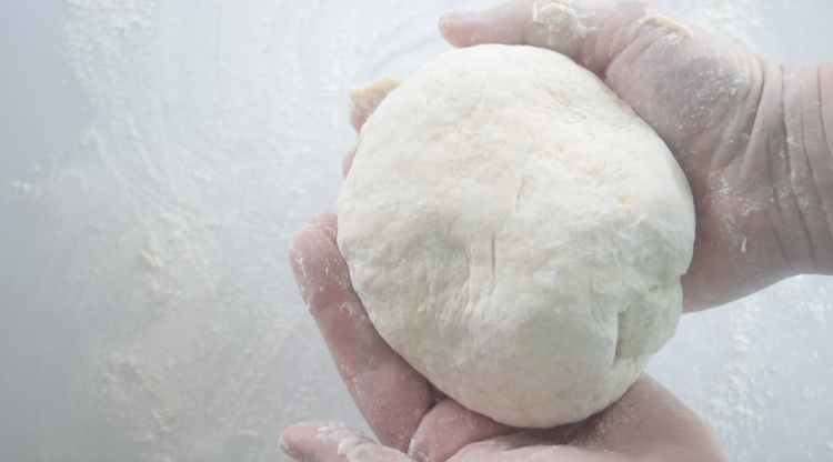 hands holding ball of dough