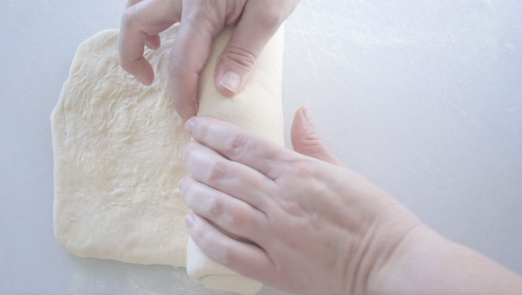 hands rolling up dough