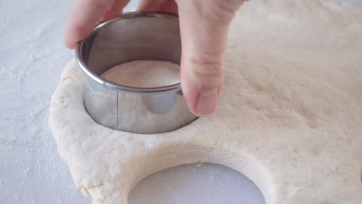 Biscuit cutter cutting biscuits into shapes.