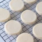 Baked circle shortbread cookies on a wire cooling rack.