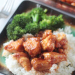 plate of rice broccoli and orange chicken