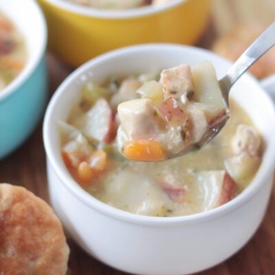 white bowl of slow cooker chicken pot pie soup and spoon