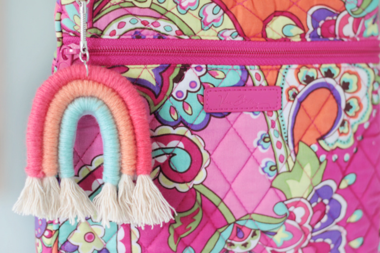 rainbow yarn keychain attached to pink purse