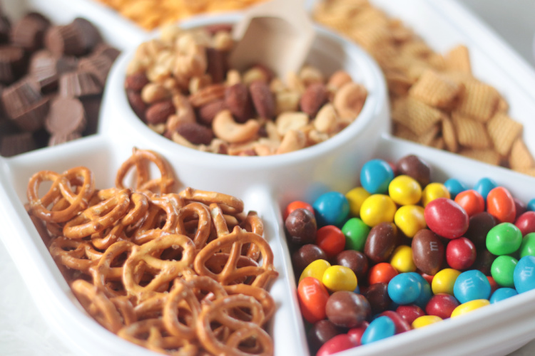 divided tray with pretzels, nuts and M&M candies